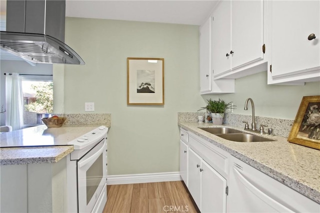 kitchen with a sink, white appliances, wall chimney exhaust hood, white cabinets, and light wood finished floors