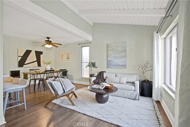 living room with lofted ceiling with beams, baseboards, wood finished floors, and ceiling fan