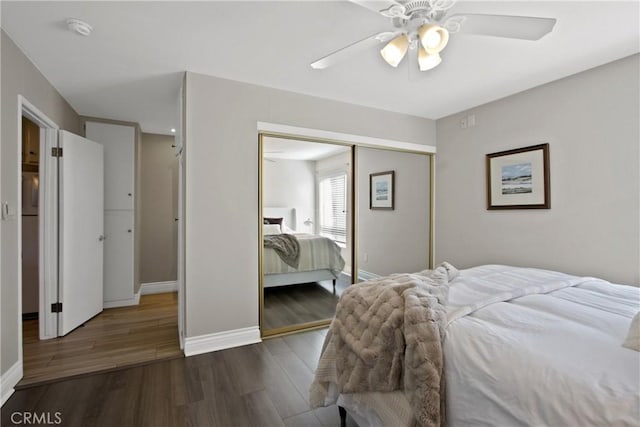 bedroom featuring a closet, ceiling fan, baseboards, and wood finished floors