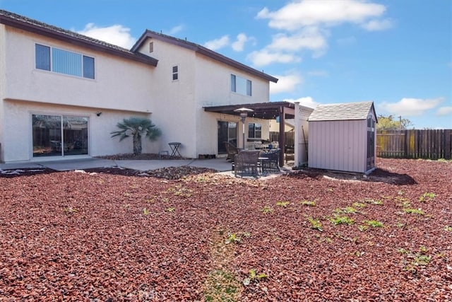 back of property featuring fence, a storage shed, an outdoor structure, a patio area, and a pergola