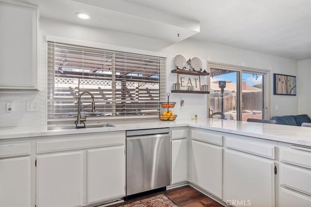 kitchen featuring a sink, backsplash, dishwasher, and white cabinetry