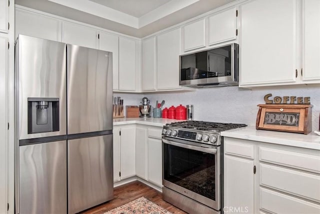 kitchen with stainless steel appliances, white cabinets, and light countertops