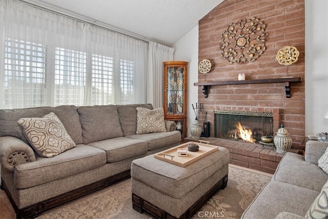 living room with lofted ceiling, a textured ceiling, and a brick fireplace