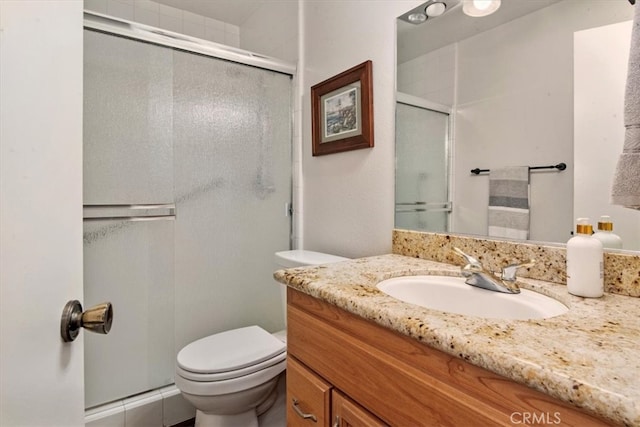 full bath featuring vanity, toilet, and a shower stall