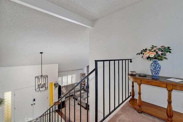 hallway featuring a chandelier, a textured ceiling, stairs, and carpet floors