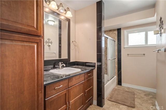 bathroom featuring tile patterned floors, combined bath / shower with glass door, vanity, and baseboards