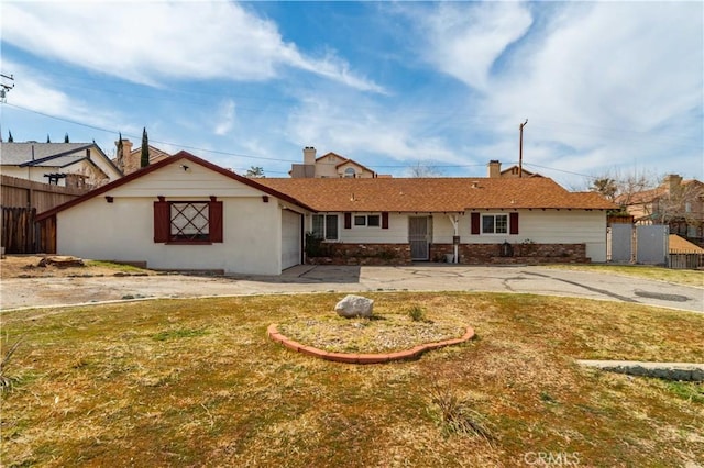 view of front of house with concrete driveway, an attached garage, and fence