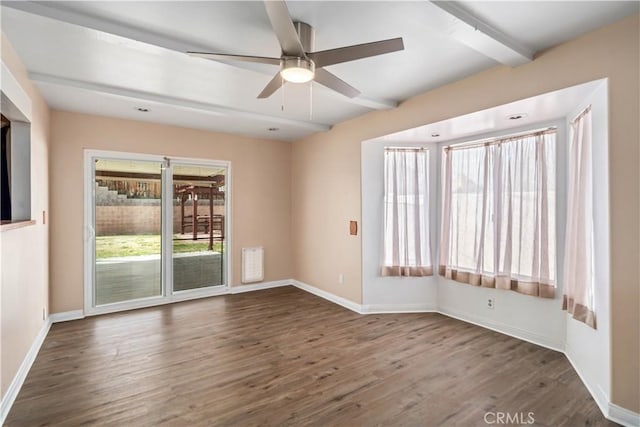 spare room with beamed ceiling, a ceiling fan, baseboards, and wood finished floors