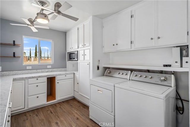 washroom featuring cabinet space, independent washer and dryer, a ceiling fan, and wood finished floors