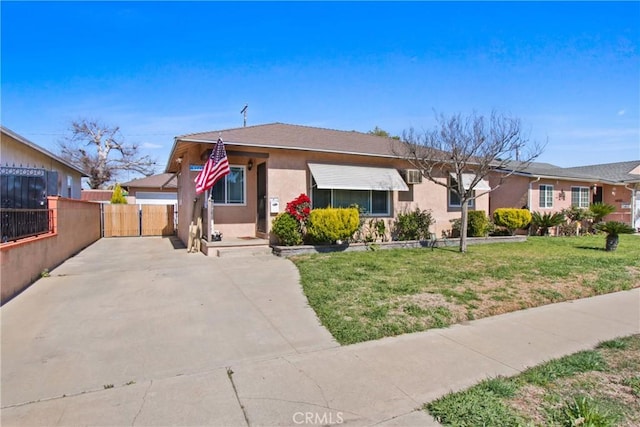 view of front facade with stucco siding, a front lawn, and fence