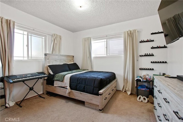 bedroom featuring multiple windows, light colored carpet, and a textured ceiling