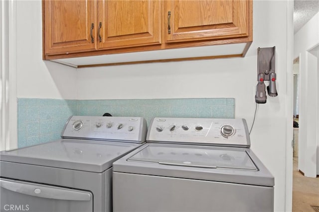 washroom featuring cabinet space and separate washer and dryer