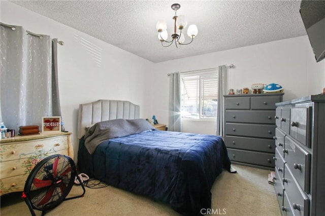 bedroom with a notable chandelier, light colored carpet, and a textured ceiling