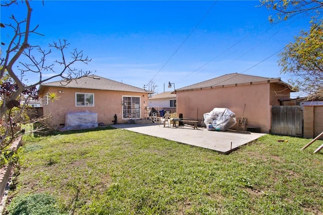 back of house featuring a yard, a patio area, fence, and stucco siding