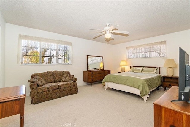 carpeted bedroom featuring a textured ceiling and a ceiling fan