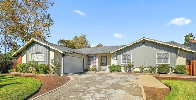 ranch-style home with an attached garage, concrete driveway, board and batten siding, and fence