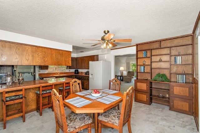 dining area featuring a textured ceiling and a ceiling fan