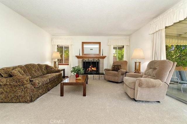 living area with light colored carpet, a brick fireplace, and a textured ceiling