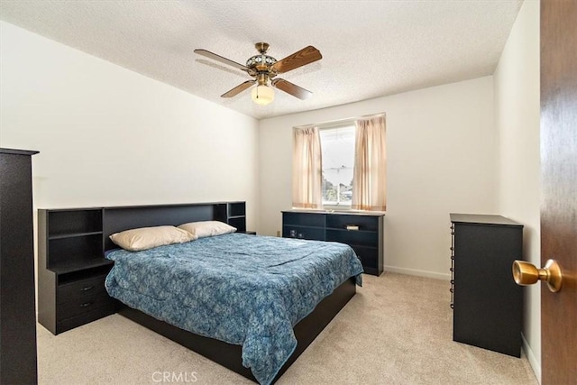 bedroom featuring baseboards, light colored carpet, ceiling fan, and a textured ceiling