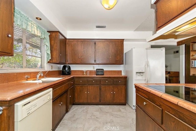 kitchen with white appliances, visible vents, a sink, tile counters, and marble finish floor