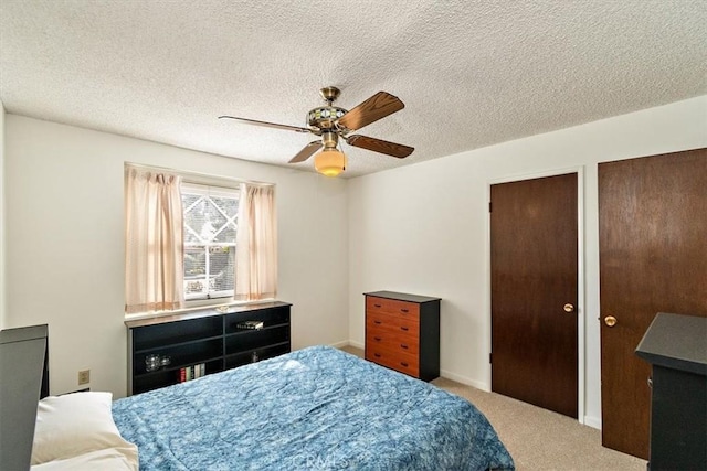 bedroom featuring multiple closets, a textured ceiling, carpet floors, baseboards, and ceiling fan