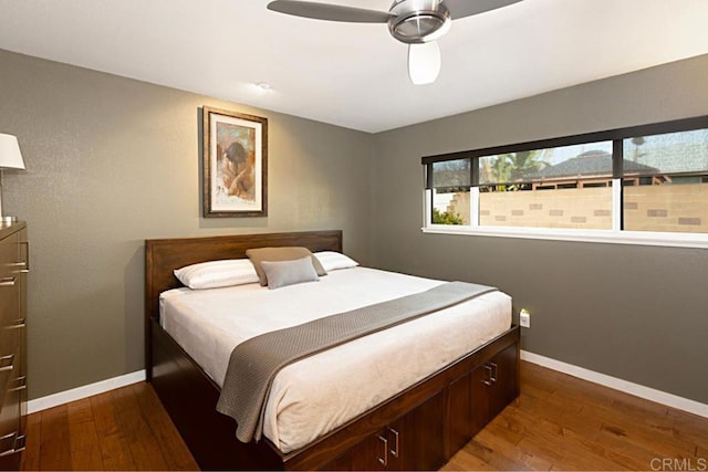 bedroom featuring wood finished floors, baseboards, and ceiling fan