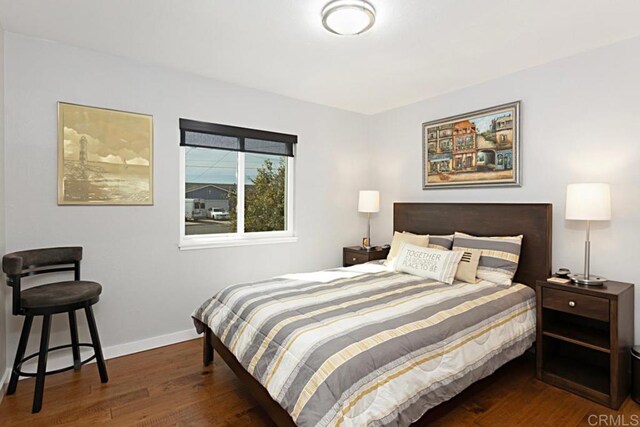 bedroom with wood finished floors and baseboards