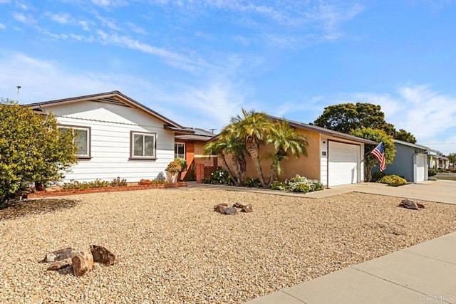 single story home with solar panels, driveway, and a garage