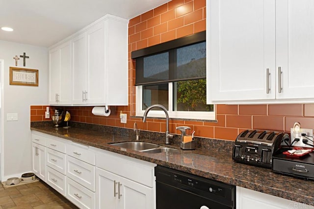 kitchen with a sink, black dishwasher, stone tile flooring, white cabinetry, and decorative backsplash