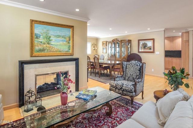 living area with crown molding, baseboards, light wood-type flooring, recessed lighting, and a fireplace