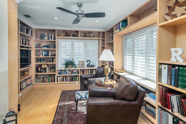 sitting room featuring visible vents, ornamental molding, ceiling fan, and wood finished floors