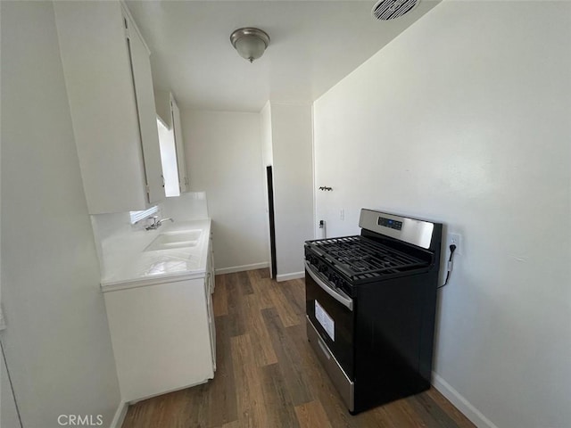 kitchen featuring a sink, visible vents, gas range, and dark wood-style floors