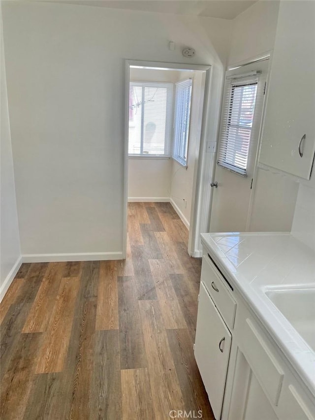 bathroom featuring vanity, baseboards, and wood finished floors