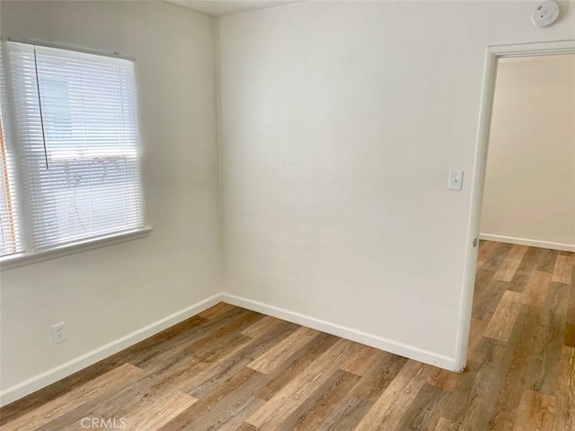 empty room featuring baseboards and wood finished floors