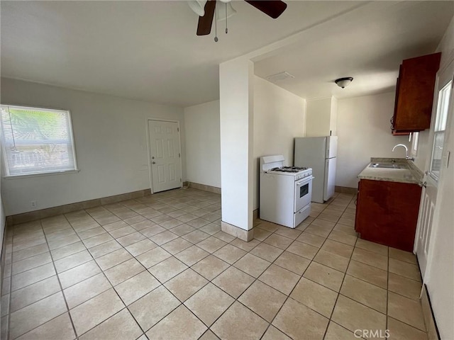 kitchen featuring light tile patterned floors, white appliances, ceiling fan, and a sink