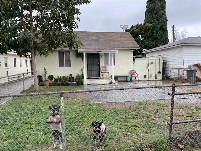 bungalow with a fenced backyard, stucco siding, a front lawn, and roof with shingles