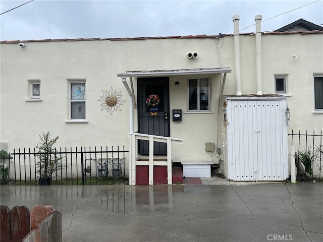 view of front of home with fence and stucco siding