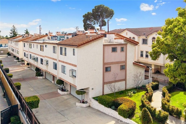 view of property with a residential view and concrete driveway