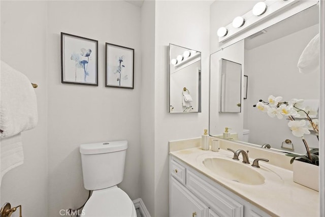 half bathroom with vanity and toilet