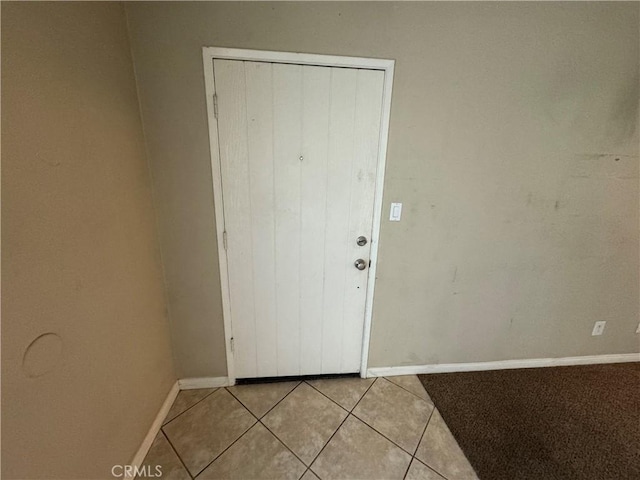 foyer featuring light tile patterned flooring and baseboards