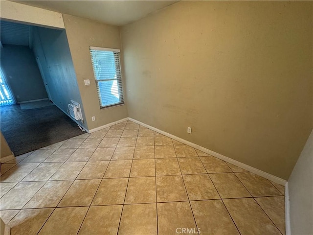 empty room with light tile patterned floors and baseboards