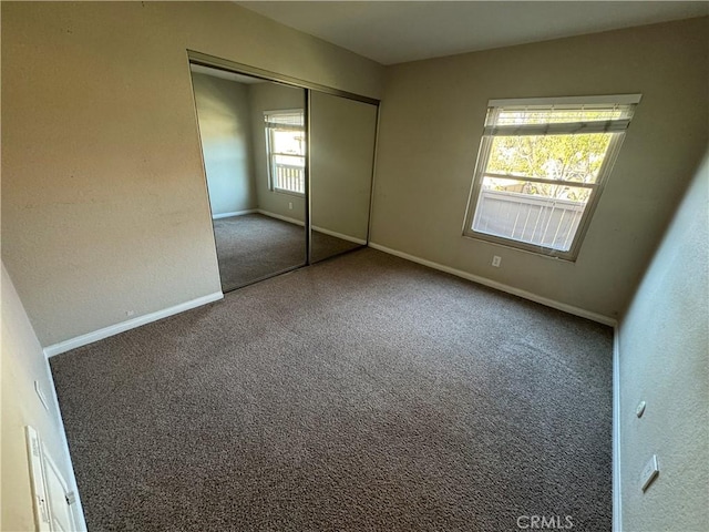 unfurnished bedroom with a closet and baseboards