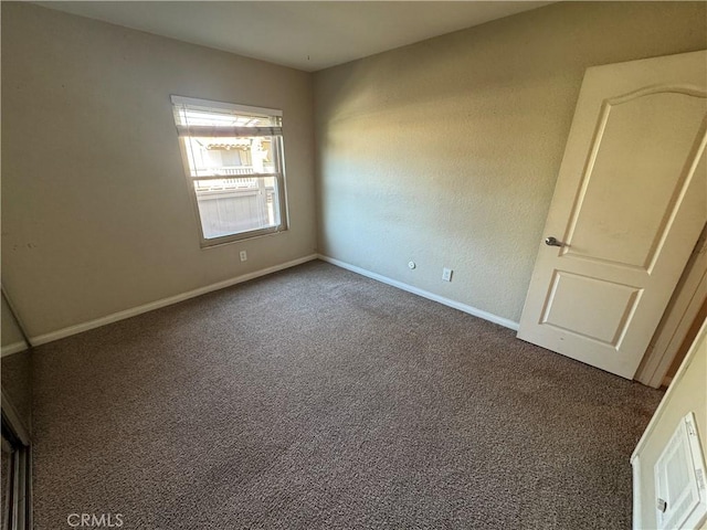 carpeted spare room featuring baseboards