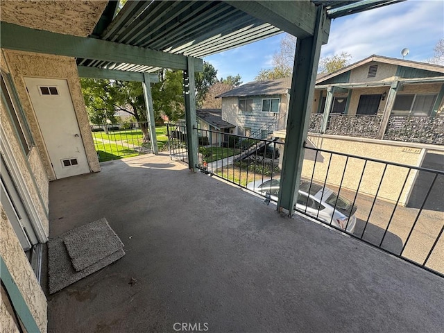 view of patio with a pergola and a balcony