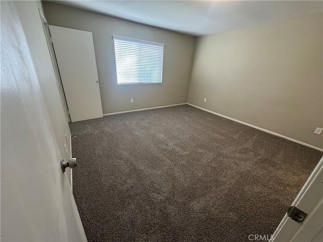 empty room featuring baseboards and carpet