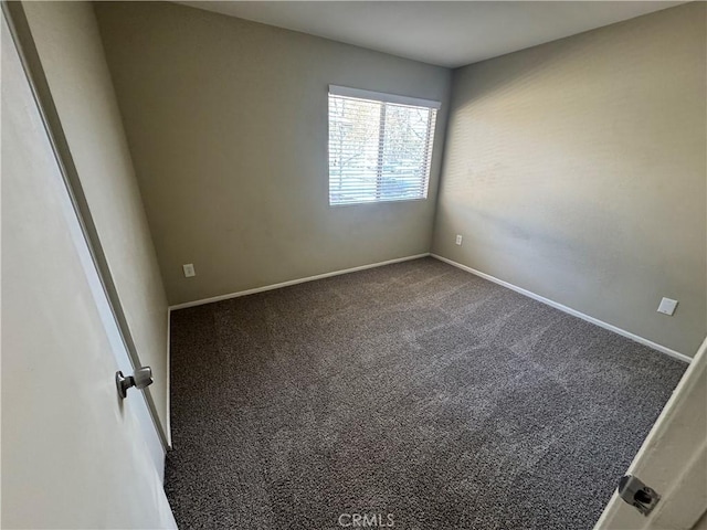 carpeted spare room featuring baseboards