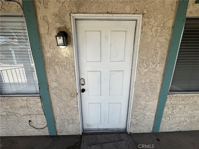 entrance to property featuring stucco siding