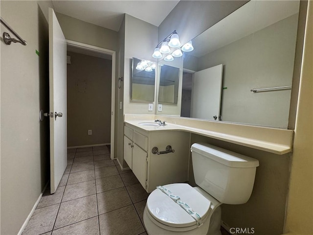 half bath featuring tile patterned floors, toilet, vanity, and baseboards