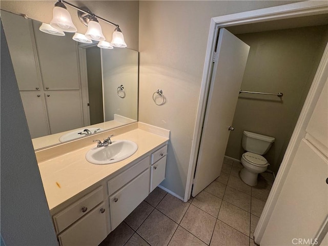 bathroom featuring tile patterned floors, baseboards, toilet, and vanity