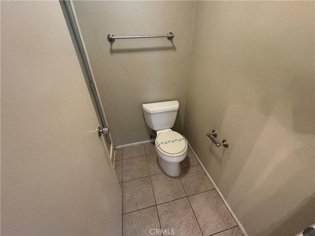 bathroom featuring tile patterned floors, toilet, and baseboards